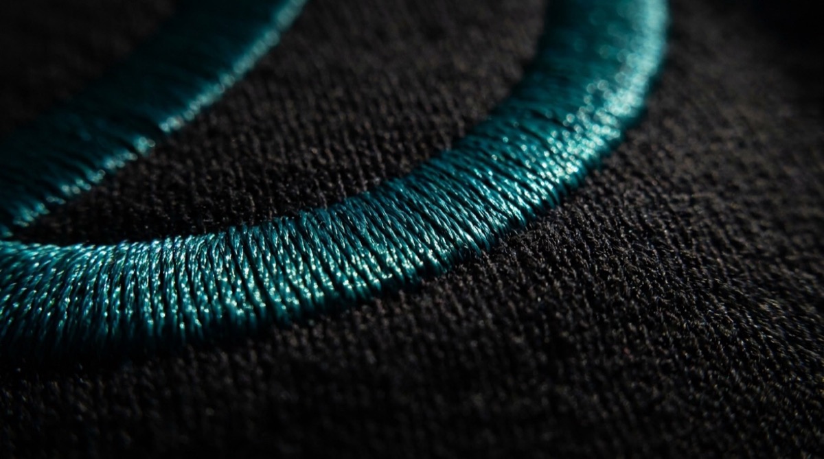 Macro photograph of teal satin stitch embroidery